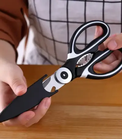 A chef holding kitchen scissors.